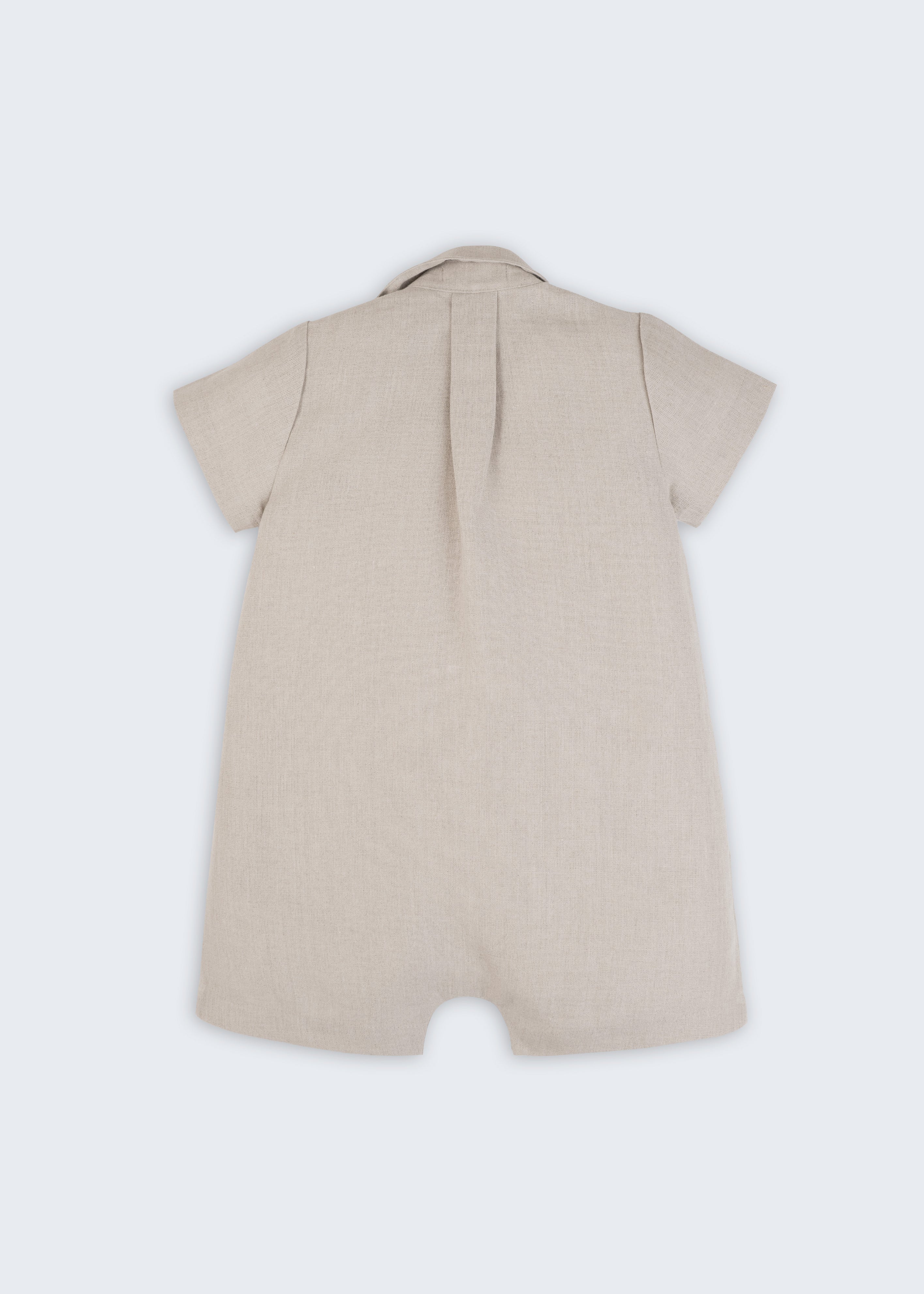 Macacão infantil unissex em linho cru com bordado de cogumelo e esquilo, visto de costas.