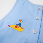 Detalhe do bordado artesanal de submarino amarelo em macaquinho infantil de linho azul, em referência a Yellow Submarine dos Beatles.