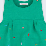 Detalhe do decote com pregas e bordados à mão de peixinhos, conchas e estrelas-do-mar em linho verde-água.