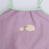 Detalhe do bordado à mão de duas ovelhinhas em macaquinho infantil lilás para bebê menina.