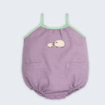 Macaquinho infantil de menina em linho lilás com viés verde, bolsos frontais e bordado artesanal de ovelhas.