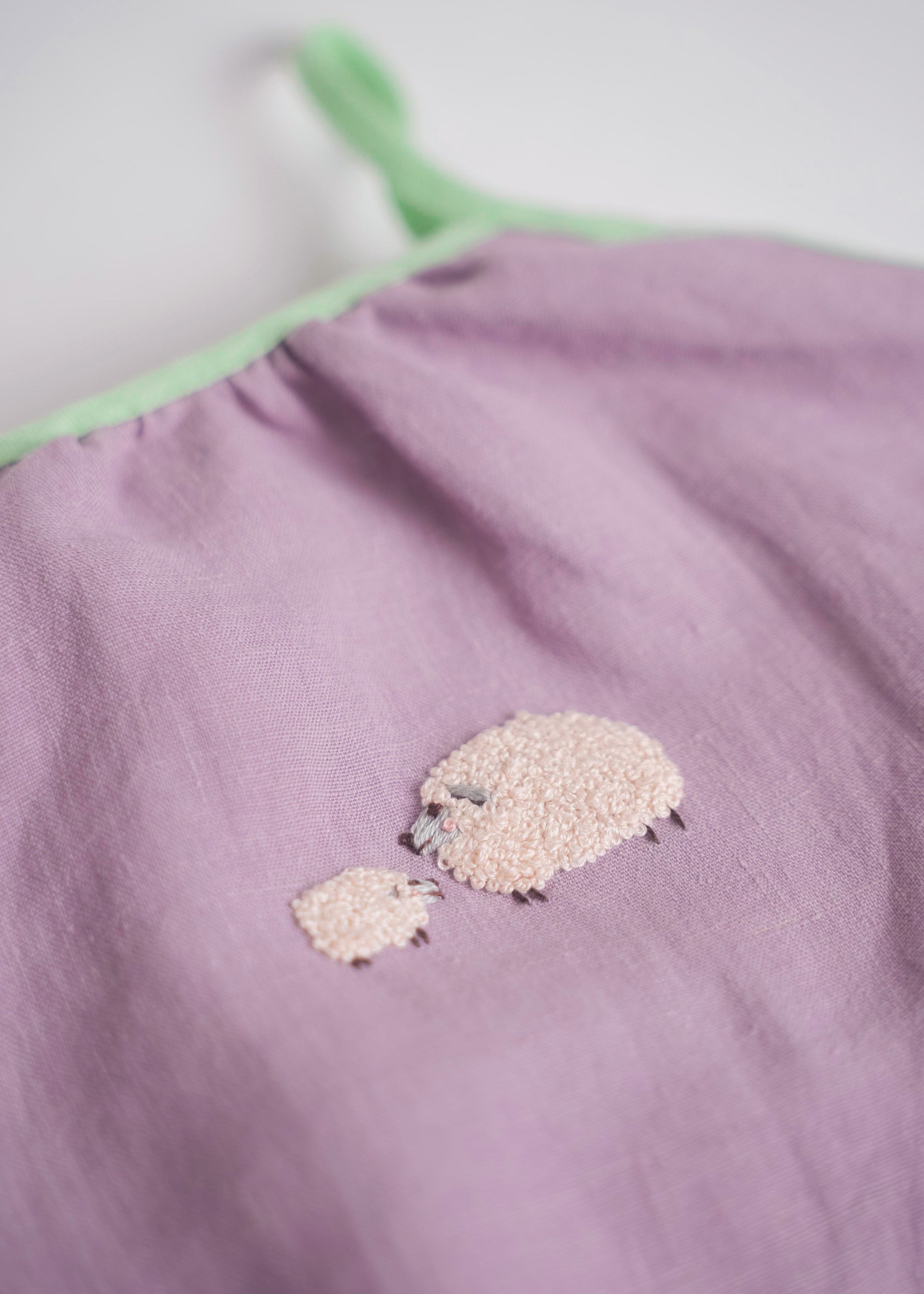 Bordado artesanal de ovelha e filhote em macaquinho infantil de linho lilás.