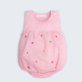 Macaquinho infantil de menina em linho rosa com bordado artesanal de pequenas flores coloridas.