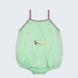 Macaquinho infantil em linho verde menta com alças finas na cor lilás, bolsos frontais e patinhos bordados à mão na altura da barriga, para bebês meninos e meninas.