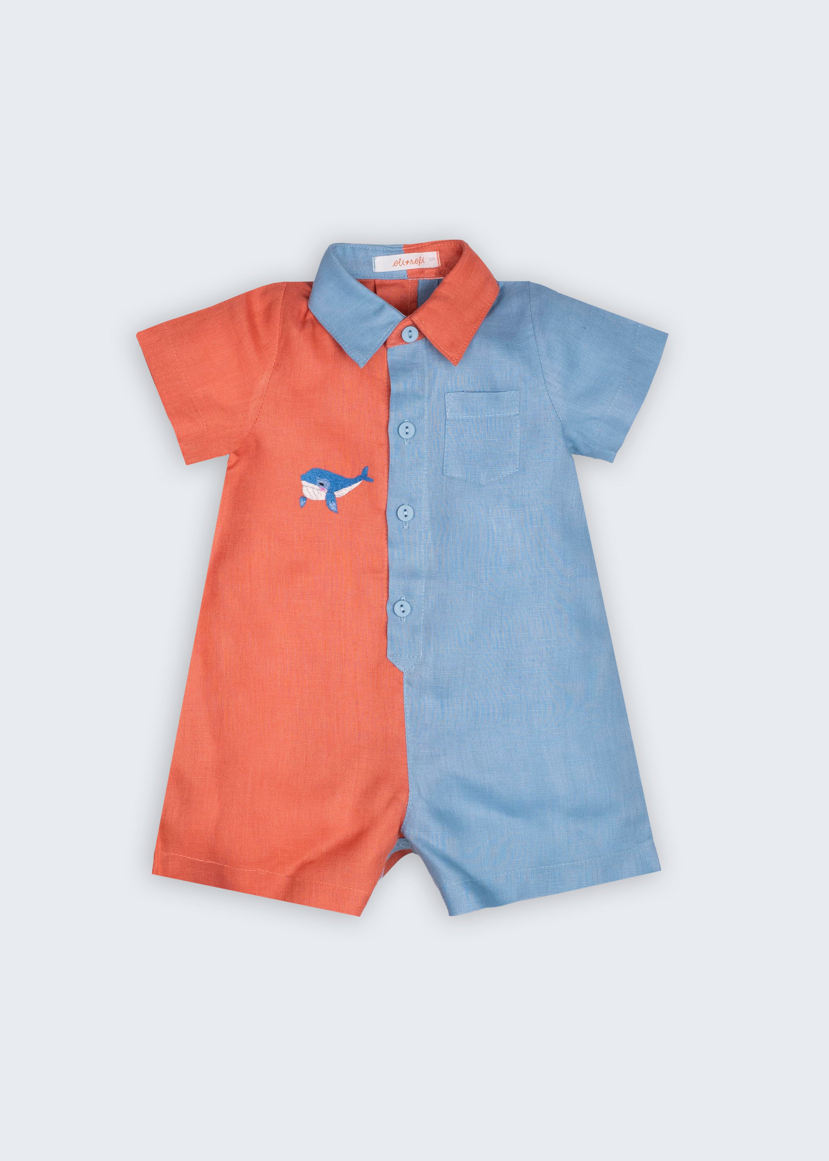 Macaquinho Tiê infantil em 100% linho bicolor coral e azul celeste, com gola contrastante, bolso e baleia bordada à mão.
