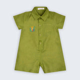 Macaquinho Tiê infantil em 100% linho verde com gola, bolso frontal, botões e onça bordada à mão, vista frontal.