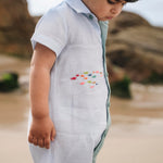Menino com macaquinho de linho bicolor com cardume de peixes coloridos bordado.