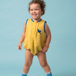 Bebê usando macaquinho infantil amarelo e azul em linho puro com bordado à mão de arara azul