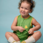 Bebê usando macaquinho verde em linho puro com bordado de canarinho e acabamento amarelo
