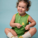 Bebê usando macaquinho verde em linho puro com bordado de canarinho e acabamento amarelo