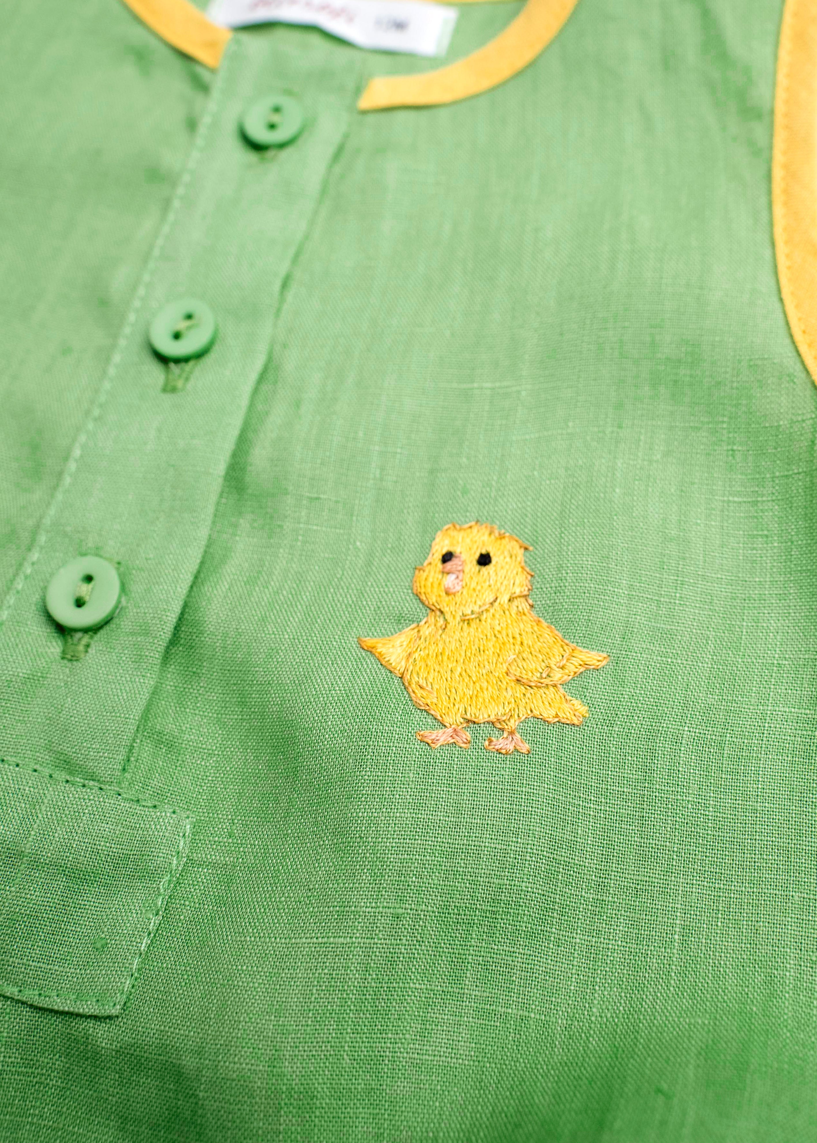 Detalhe do bordado à mão de canarinho em macaquinho bebê de linho verde e amarelo