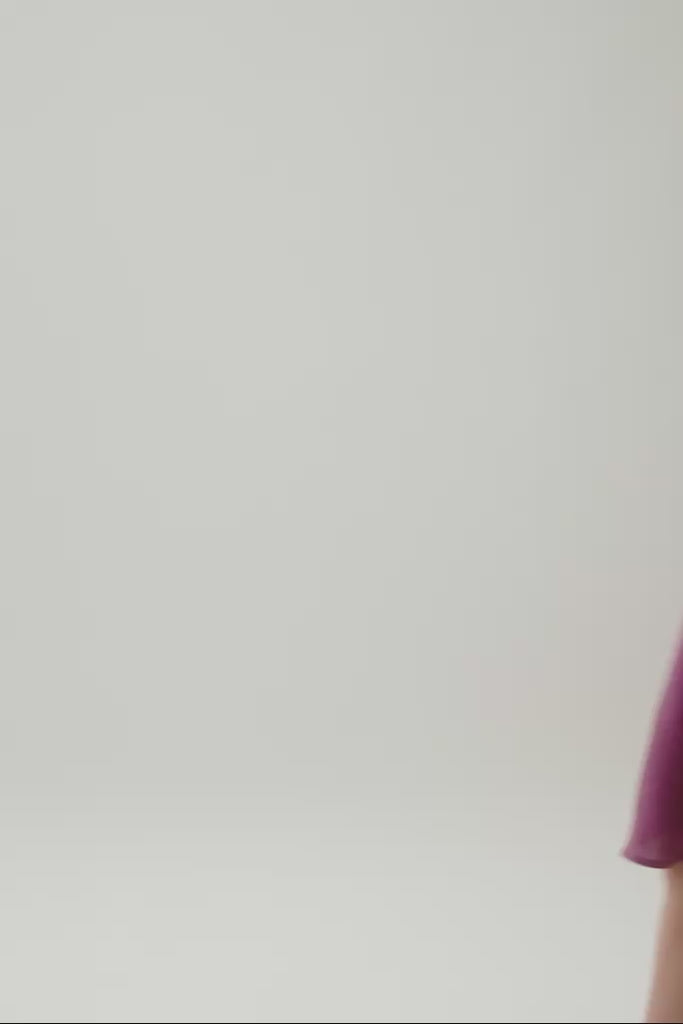 Menina usando vestido Gabi roxo, mostrando o caimento, o tecido de linho e os detalhes bordados.