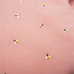 Detalhe da Regata Duda em linho rosa antigo com pequenas abelhas bordadas à mão em amarelo, preto e branco.