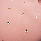 Detalhe da Regata Duda em linho rosa antigo com pequenas abelhas bordadas à mão em amarelo, preto e branco.