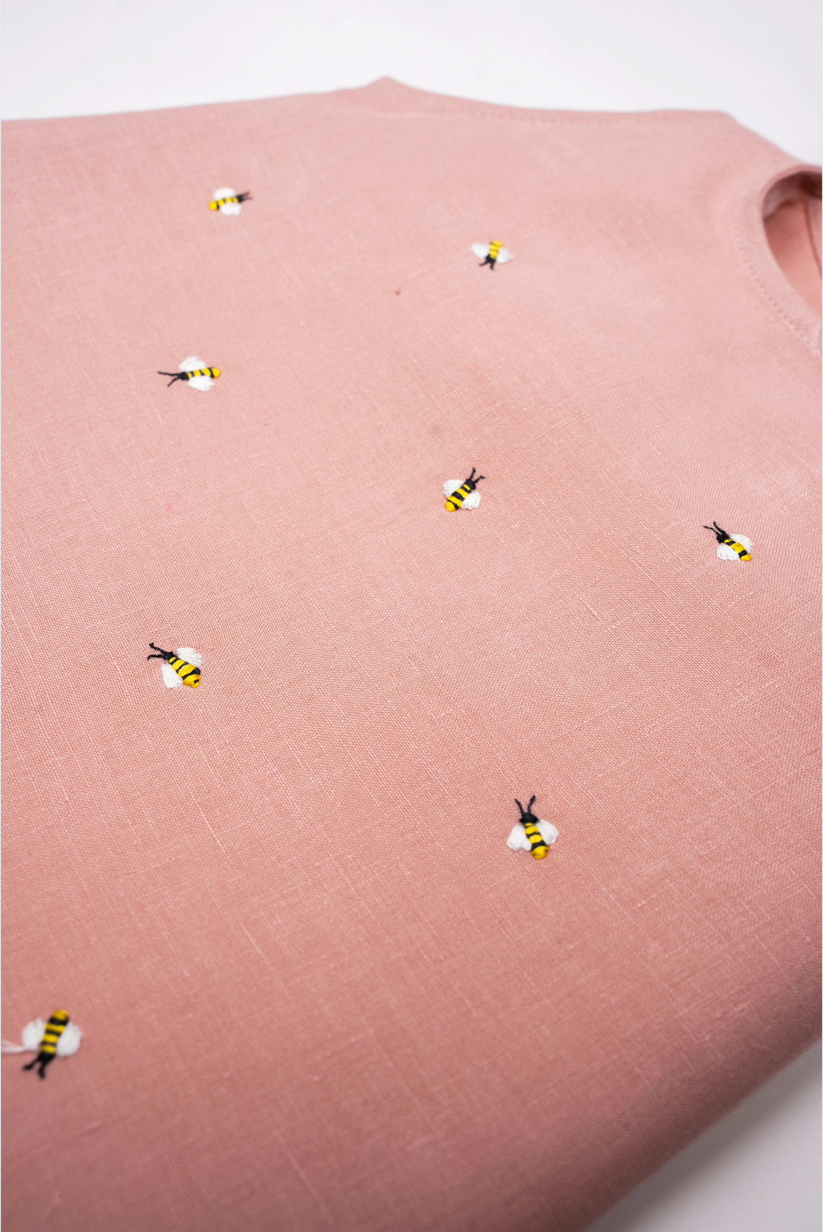 Detalhe da Regata Duda em linho rosa antigo com pequenas abelhas bordadas à mão em amarelo, preto e branco.