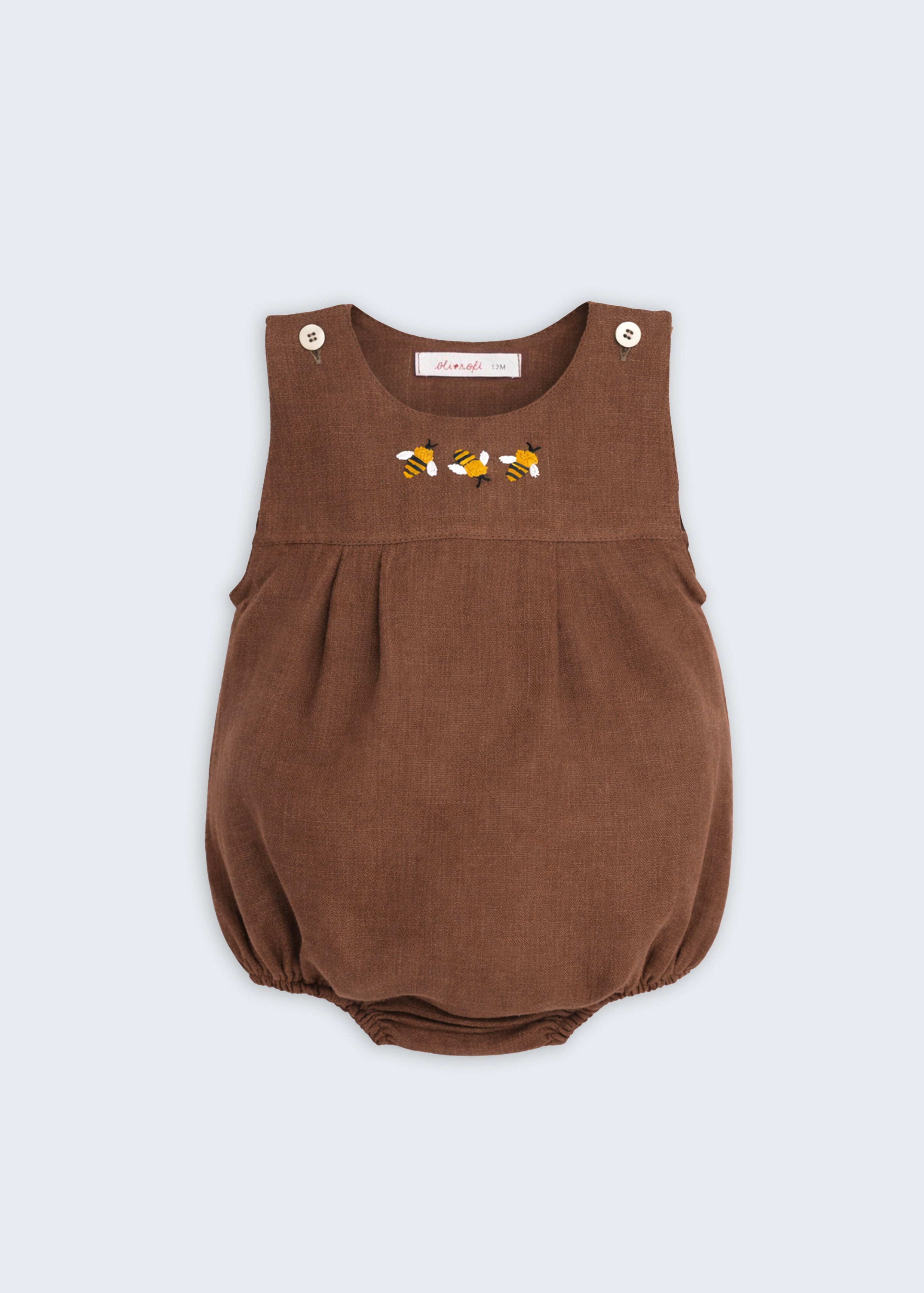 Romper de bebê em linho puro marrom com três abelhas bordadas à mão no peito.