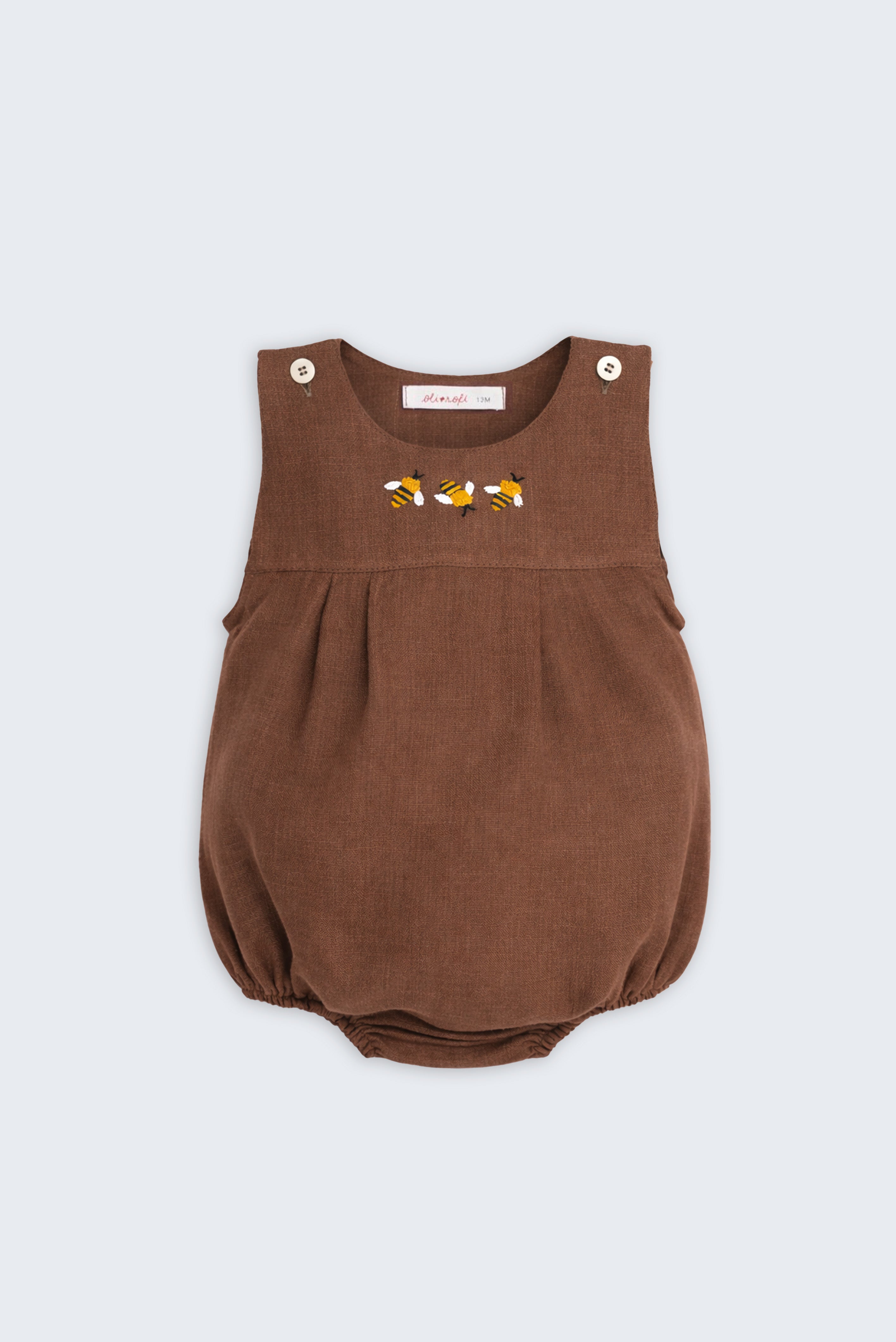 Romper de bebê em linho puro marrom com três abelhas bordadas à mão no peito.