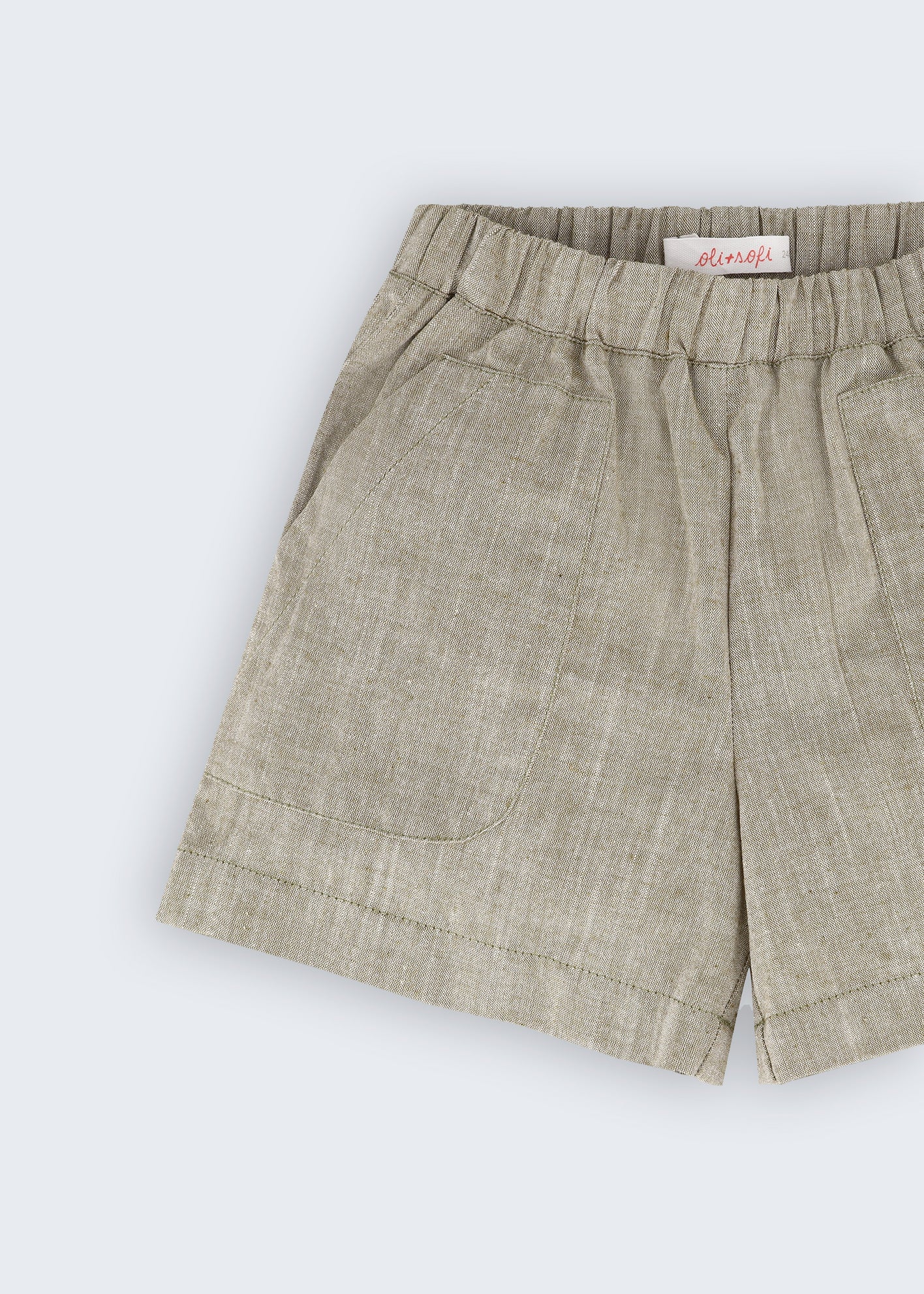 Shorts infantil verde oliva com bolsos frontais e cós de elástico visto em detalhe