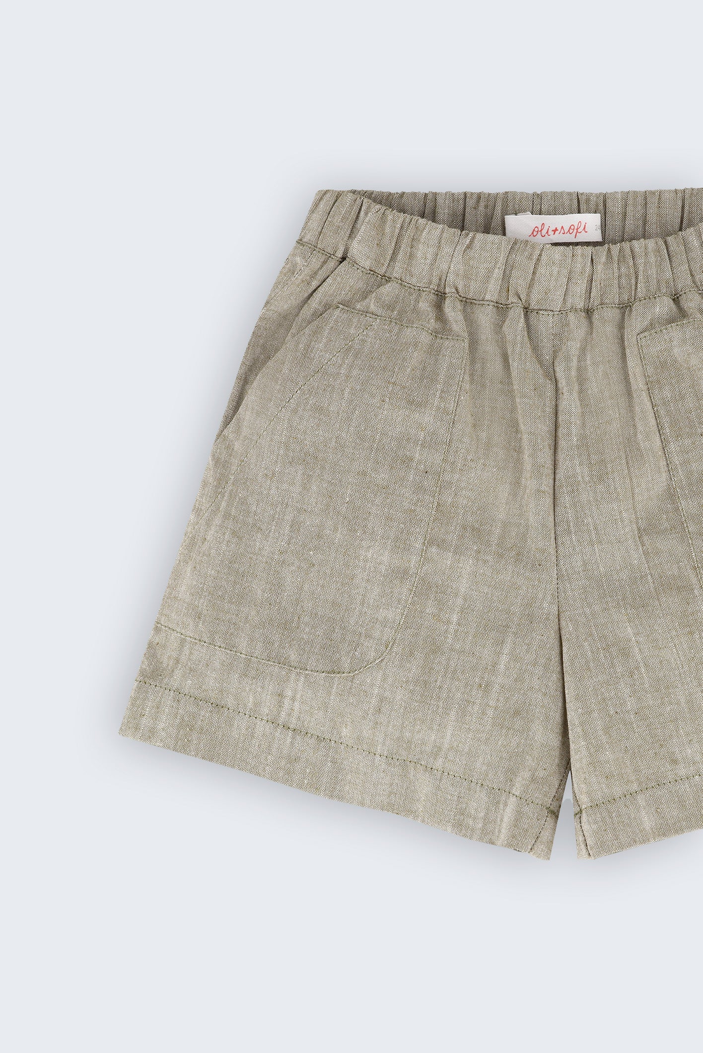 Shorts infantil verde oliva com bolsos frontais e cós de elástico visto em detalhe