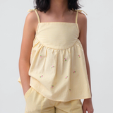 Menina vestindo Shorts Chico infantil xadrez amarelo em algodão, combinado com bata no mesmo tecido.