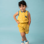 Menina usando shorts infantil amarelo em linho puro com blusa bordada de arara azul