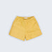 Shorts infantil em linho puro amarelo com cintura de elástico e bolsos frontais, visto de frente