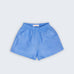 Shorts Chico infantil em 100% linho azul índigo claro, fotografado de frente, com cintura de elástico e bolsos frontais.