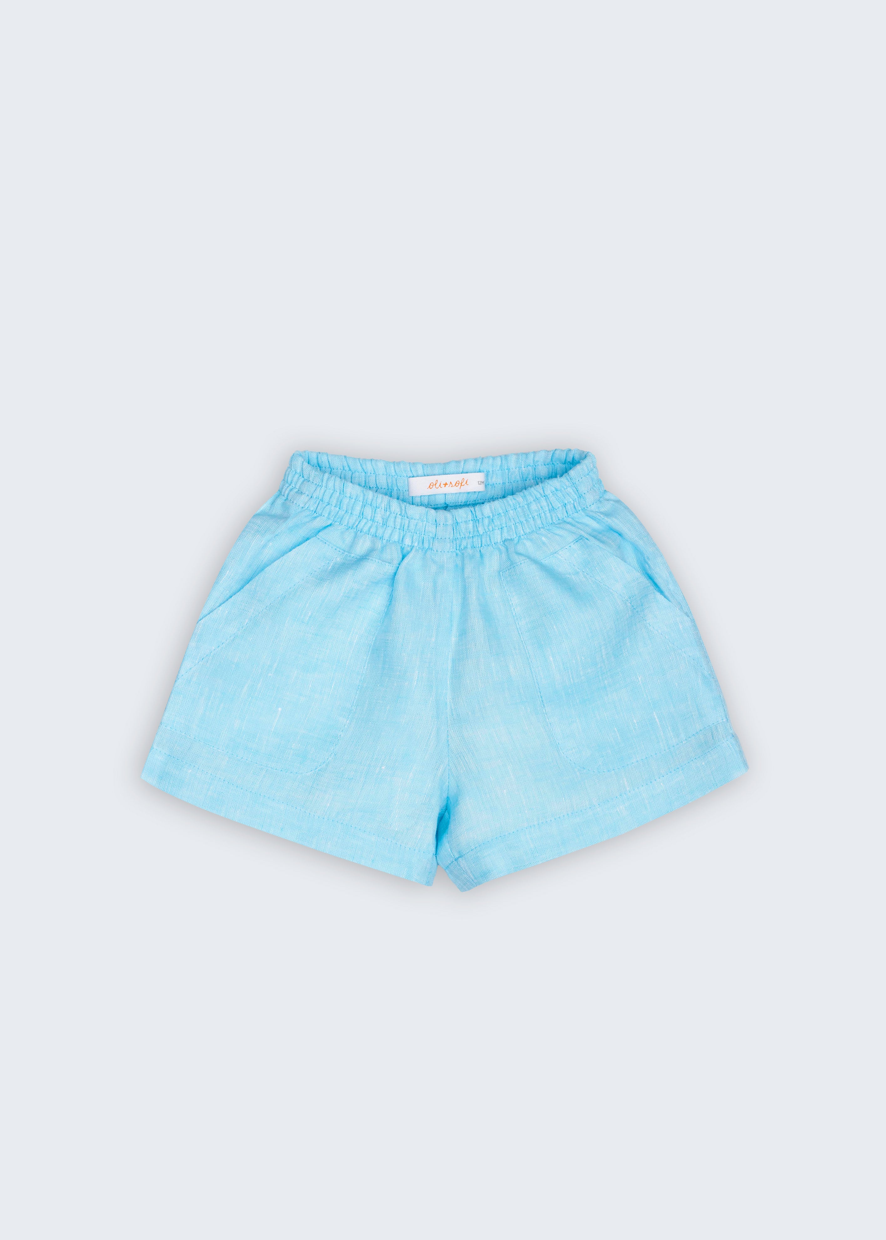 Shorts Chico infantil em 100% linho azul turquesa fotografado de frente, com cintura de elástico e bolsos frontais.