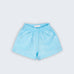 Shorts Chico infantil em 100% linho azul turquesa fotografado de frente, com cintura de elástico e bolsos frontais.