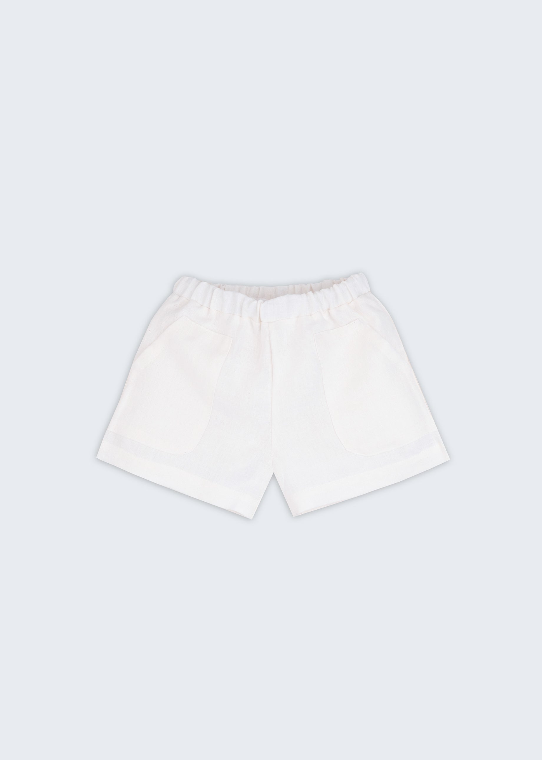 Shorts infantil em linho puro branco com bolsos frontais e cintura elástica para meninos e meninas, visto de frente.
