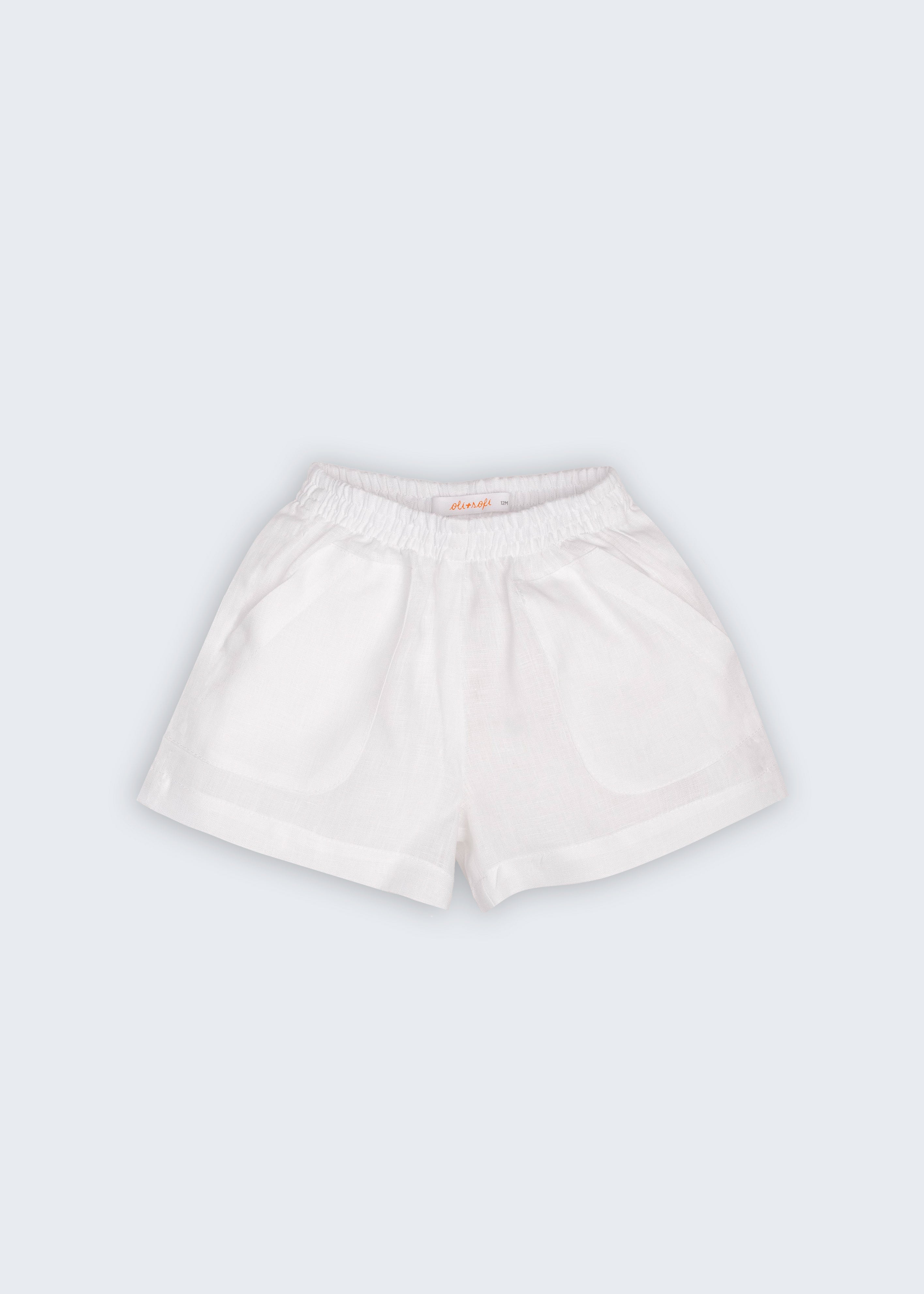Shorts Chico infantil em 100% linho branco fotografado de frente, com cintura de elástico, bolsos frontais e modelagem soltinha.