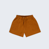 Shorts infantil em linho puro marrom terracota com bolsos frontais e cintura elástica para meninos e meninas, visto de frente.