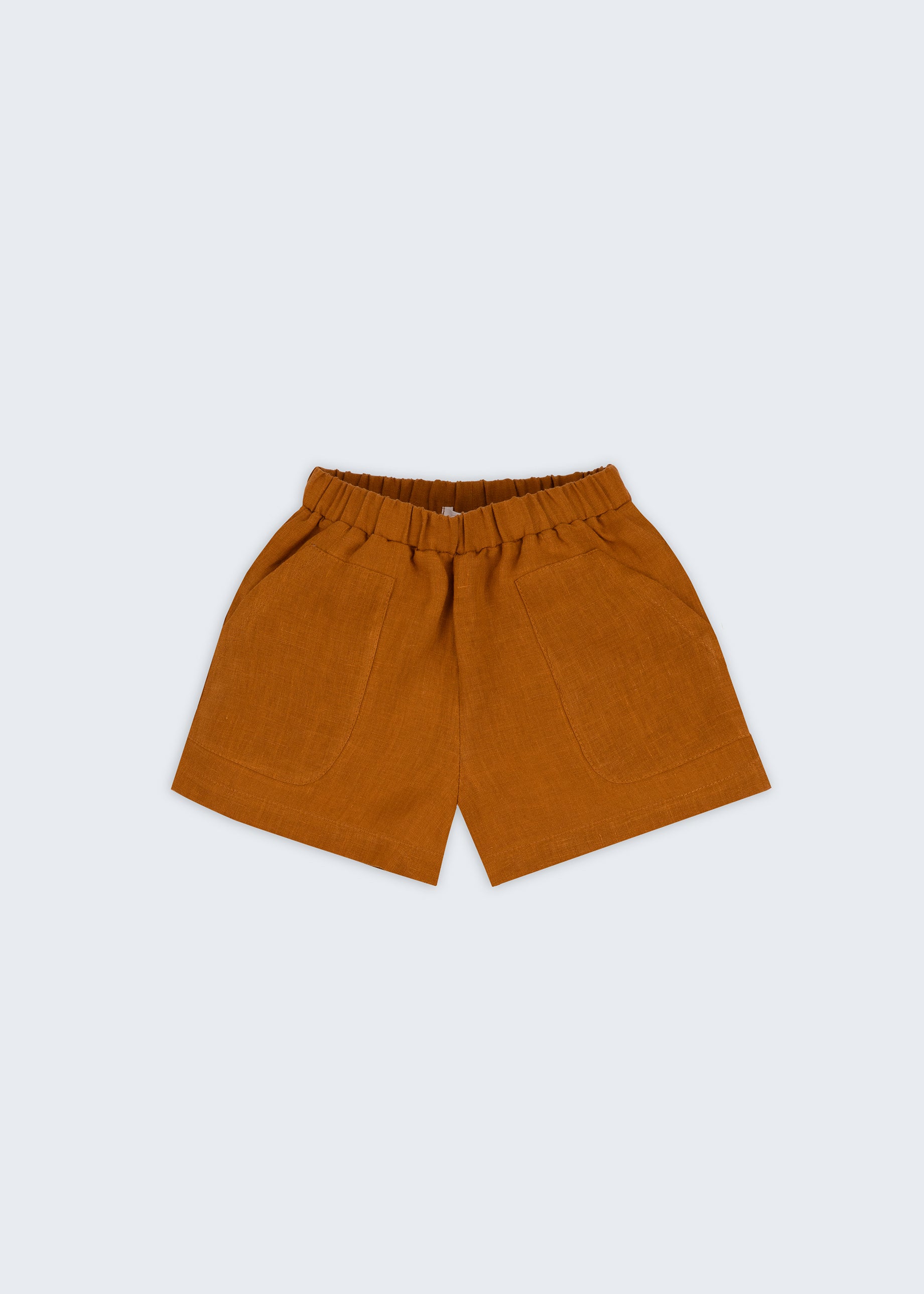 Shorts infantil em linho puro marrom terracota com bolsos frontais e cintura elástica para meninos e meninas, visto de frente.