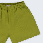 Shorts infantil em linho puro verde alfazema com bolsos frontais e cintura elástica para meninos e meninas, visto de frente em detalhe.