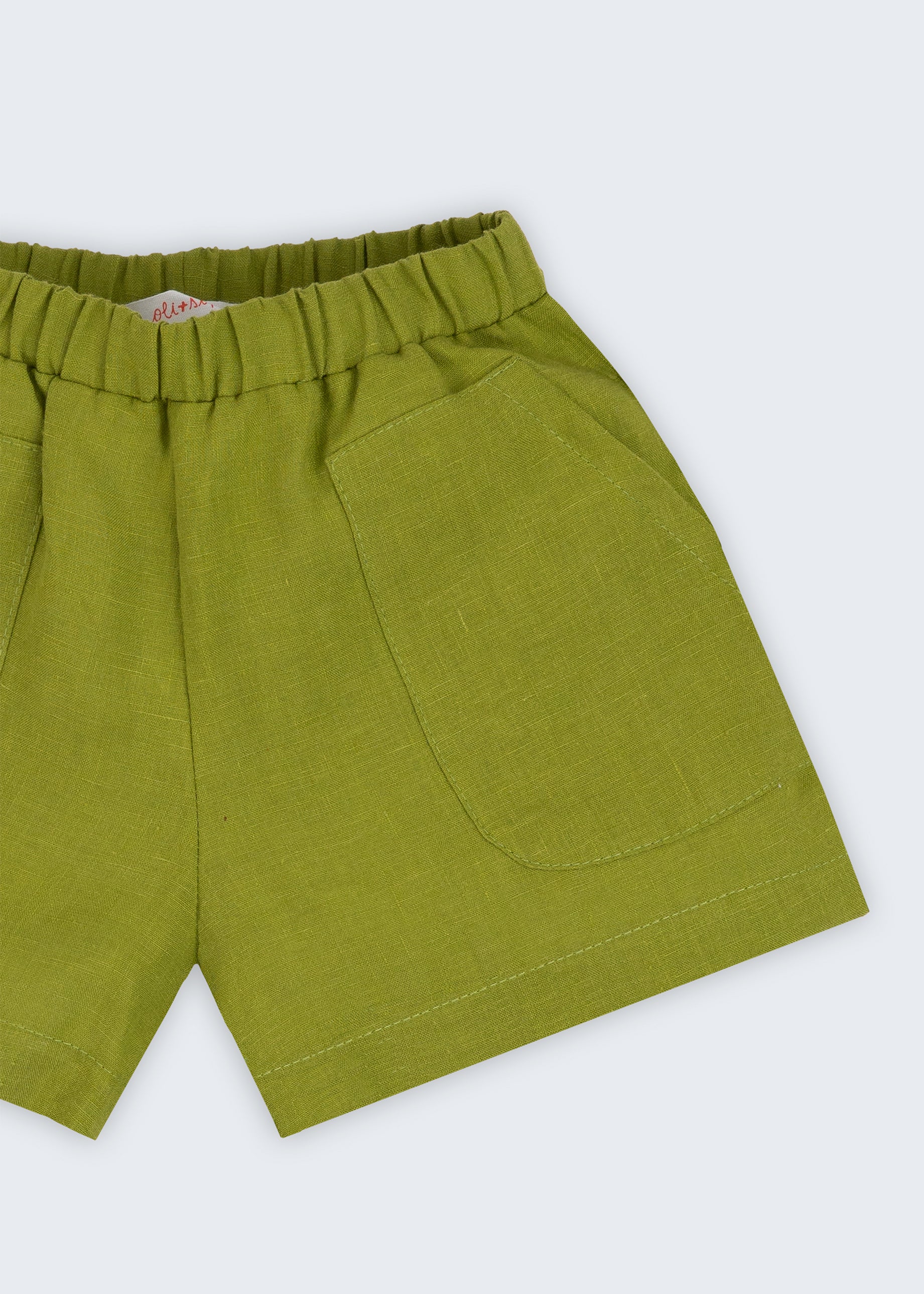 Shorts infantil em linho puro verde alfazema com bolsos frontais e cintura elástica para meninos e meninas, visto de frente em detalhe.