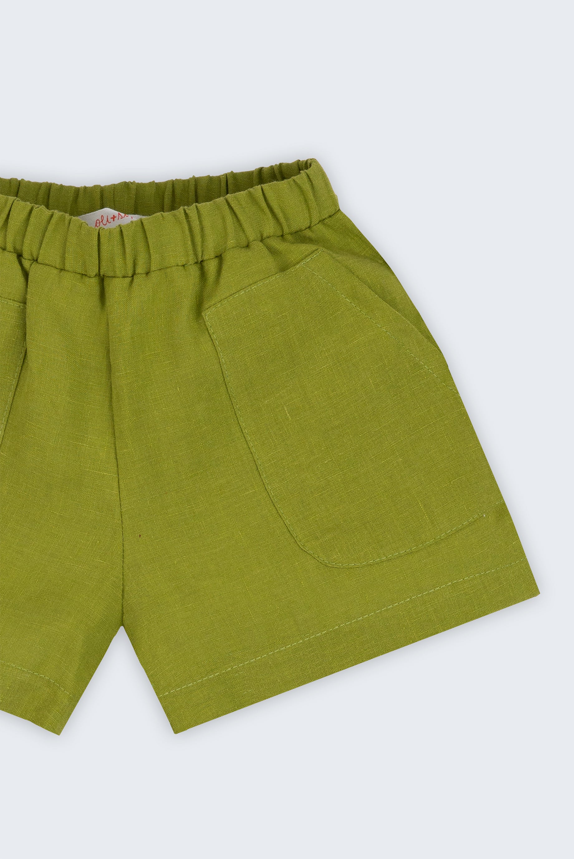 Shorts infantil em linho puro verde alfazema com bolsos frontais e cintura elástica para meninos e meninas, visto de frente em detalhe.