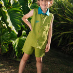 Menino usando shorts infantil em linho puro verde alfazema com bolsos frontais e cintura elástica, combinando com camisa de mesmo tom.