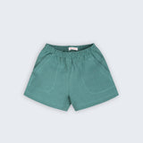 Shorts infantil em linho puro verde com cintura de elástico e bolsos frontais, visto de frente
