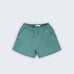 Shorts infantil em linho puro verde com cintura de elástico e bolsos frontais, visto de frente