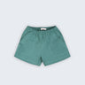 Shorts infantil em linho puro verde com cintura de elástico e bolsos frontais, visto de frente