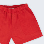 Close de shorts infantil em linho puro vermelho com bolsos frontais e cintura elástica.