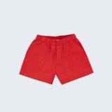 Shorts infantil em linho puro vermelho com bolsos frontais e cintura elástica para meninos e meninas, visto de frente.