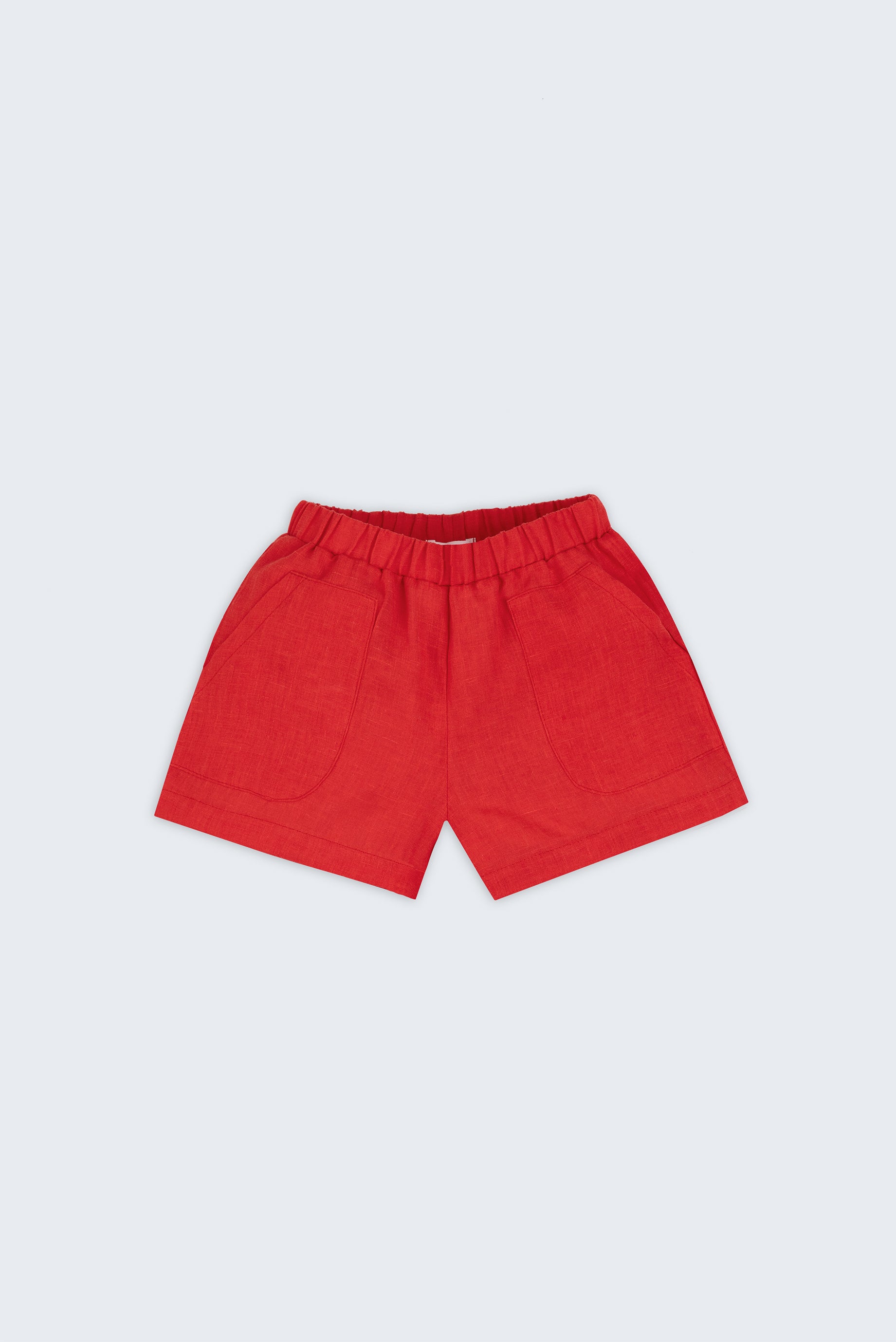 Shorts infantil em linho puro vermelho com bolsos frontais e cintura elástica para meninos e meninas, visto de frente.