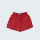 Shorts Chico infantil em linho vinho fotografado de frente, com cintura de elástico e bolsos frontais, modelo para menino e menina.