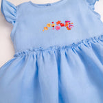 Detalhe do vestido infantil em linho azul-celeste com bordado de flores