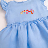 Detalhe do vestido infantil em linho azul-celeste com bordado de flores