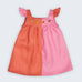 Vestido Clara infantil em 100% linho fotografado de frente, bicolor rosa e coral, com frutas bordadas à mão e botões frontais.