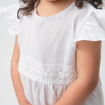 Detalhe da renda de bilro branca na cintura do Vestido Clara infantil em linho, com manga em babado.