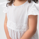 Detalhe da renda de bilro branca na cintura do Vestido Clara infantil em linho, com manga em babado.