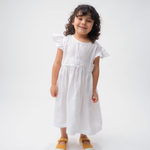 Menina vestindo Vestido Clara infantil em 100% linho branco com renda de bilro na cintura e mangas em babado.